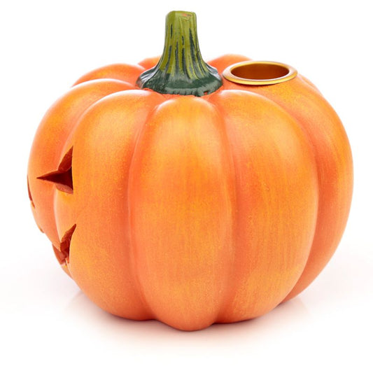 A carved, orange pumpkin with a green stem and a small round hole on top sits against a plain, white background.