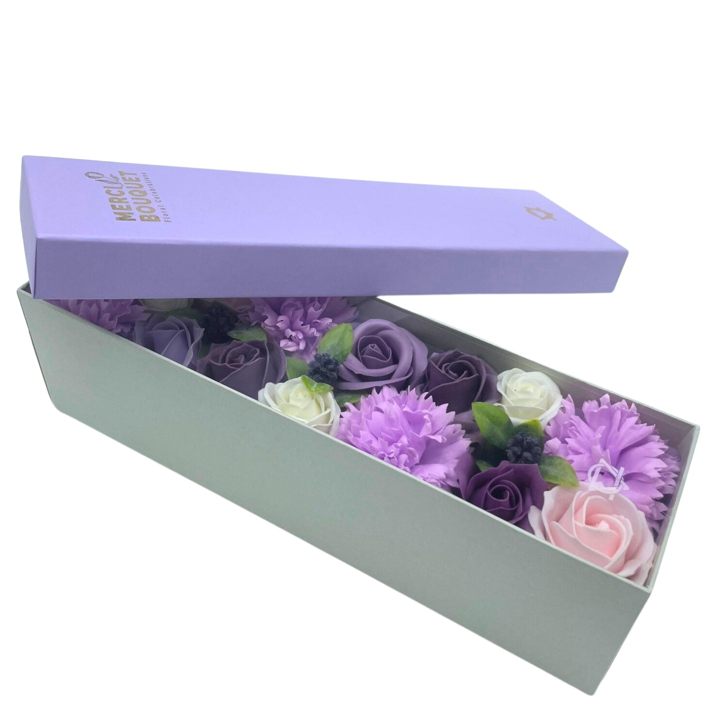 A soap flower bouquet, arranged in a light green box with a lavender lid, sits on a white background. The lid displays "MERCI BOUQUET Floral Collection".