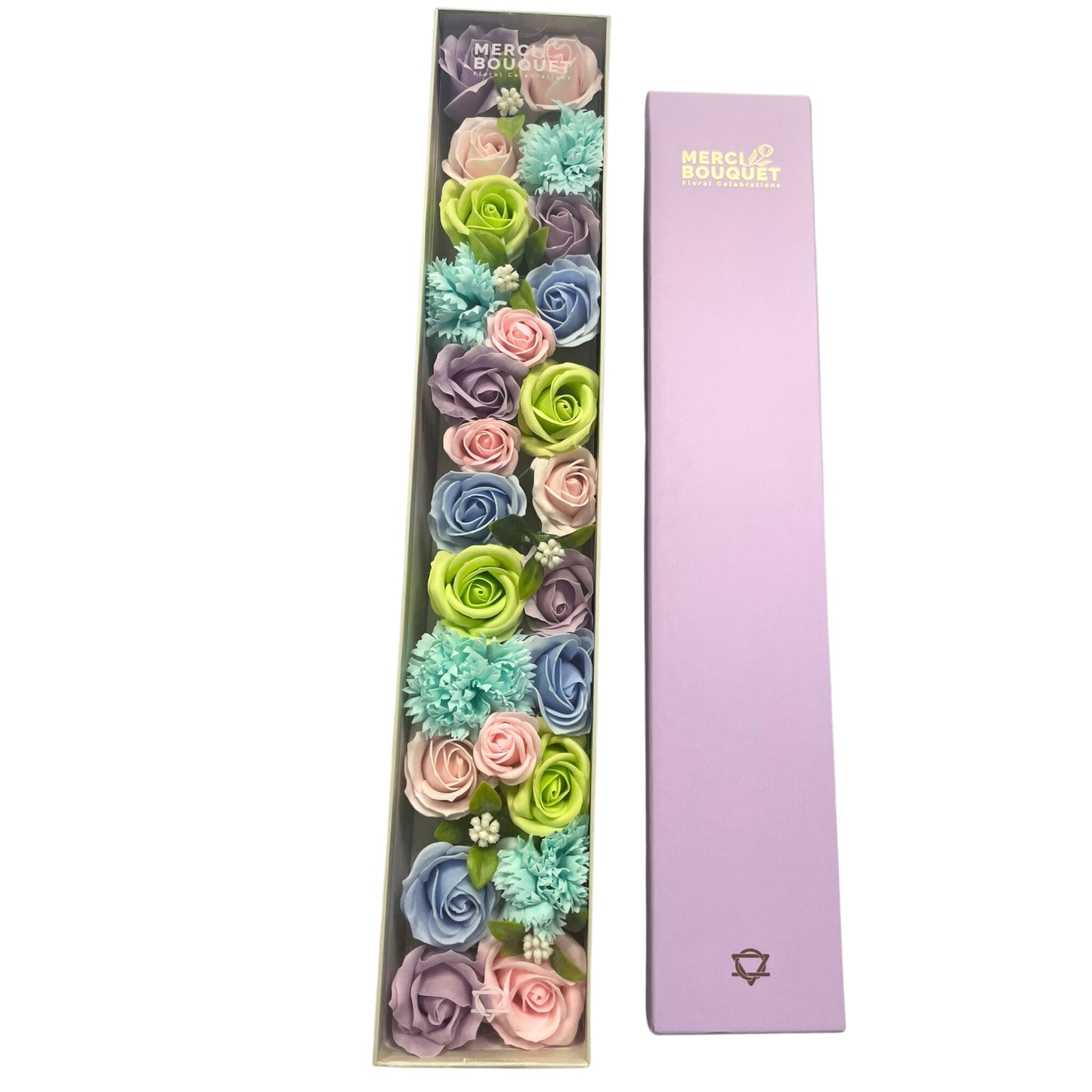 A long, rectangular box containing pastel soap flowers sits next to its matching lavender lid. MERC BOUQUET Floral Celebrations is printed on both the box and the lid.