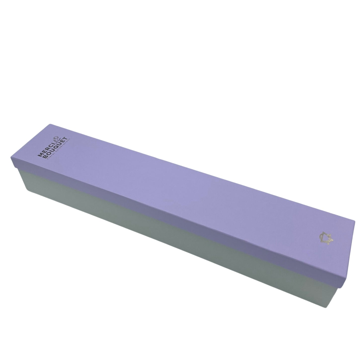 A long, rectangular lavender box rests on a white background. The top is lavender, the bottom is light gray. It reads: MERC BOUQUET / Floral Creations. A small logo is present.