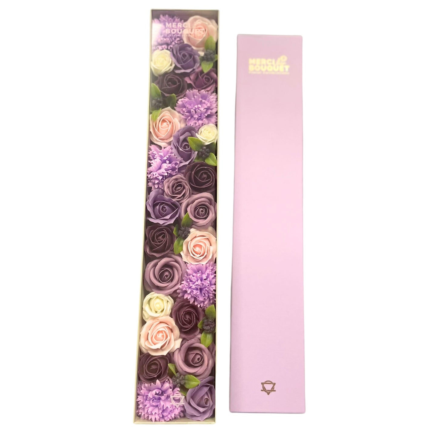 Soap flowers, arranged vertically in a clear box, are presented alongside a matching light purple cover. "MERCI BOUQUET" is printed on both the box and the cover.