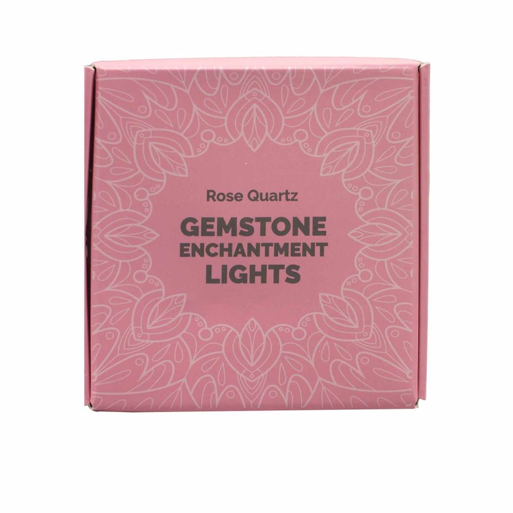 A pink box displays "Rose Quartz GEMSTONE ENCHANTMENT LIGHTS" in bold font. A decorative, stylized pattern of floral elements surrounds the text on the box’s surface.