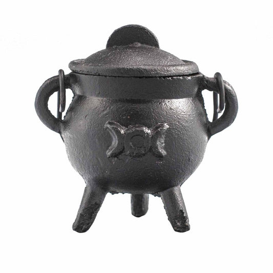 A small black cauldron with a lid sits on three legs. It has two side handles and a triple moon symbol embossed on its front. The background is plain white.