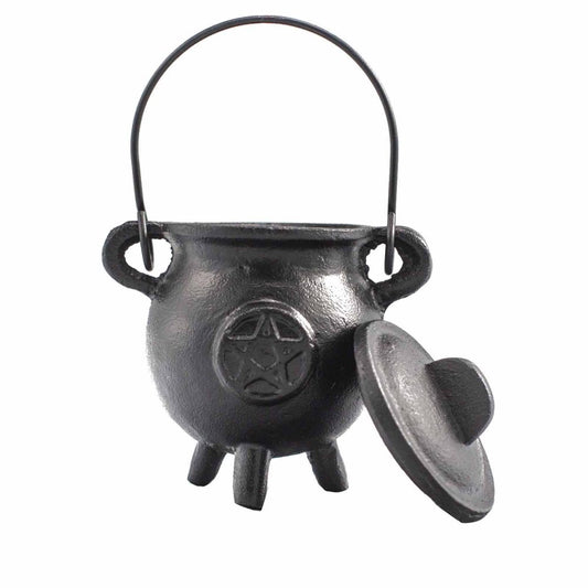 A small black cauldron with a pentagram design sits on three legs and has a detached lid. It features a handle and is set against a plain white background.