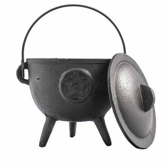 A black cast iron cauldron with three legs and a handle, featuring a pentacle design. Its lid is slightly ajar, placed in a plain white background.