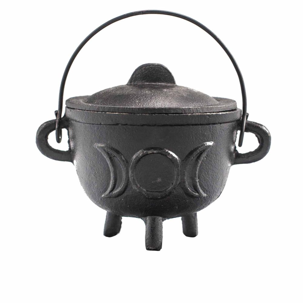 A small black cast iron cauldron with a lid and handle, featuring a triple moon design, sits on three short legs against a plain white background.