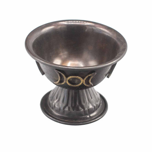 A small, bronze chalice with a flared base featuring a triple moon symbol in gold, set against a plain background.