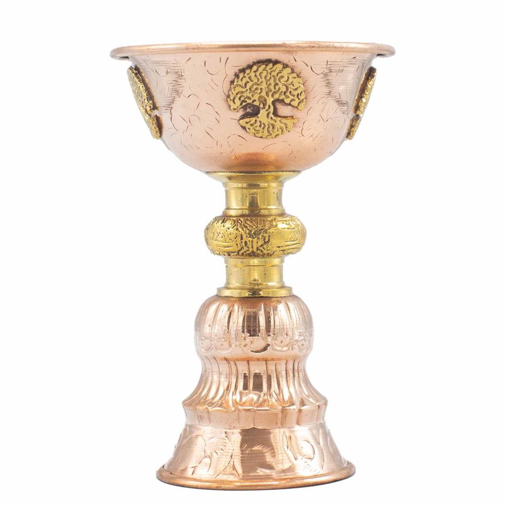 Ornate copper cup elevated on a decorative golden stand adorned with intricate engravings and embossed designs, featuring a tree motif, isolated against a white background.
