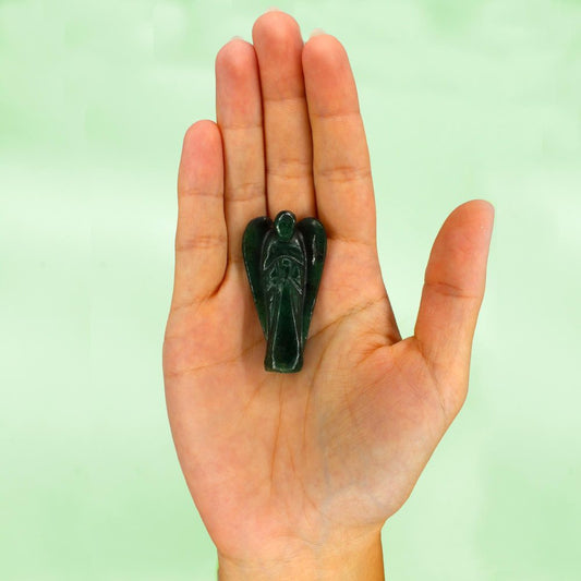 A small, green, carved-jade angel figurine sits in the palm of a person's hand, displayed against a light-green background.