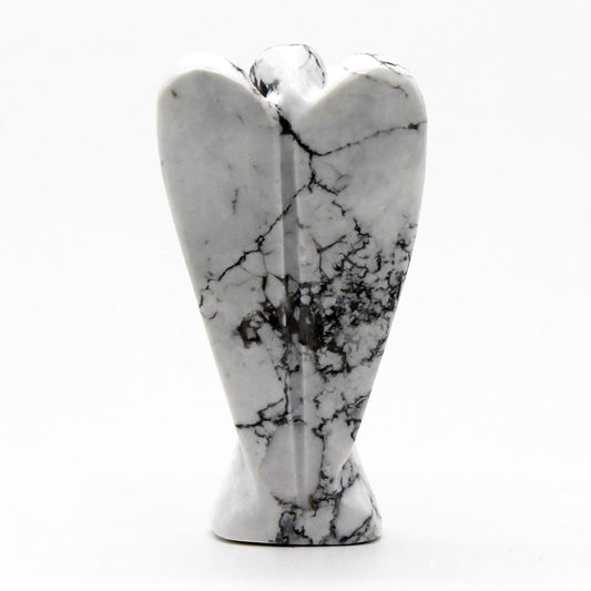 A marble angel figurine stands on a white surface. The angel is white with black veining.