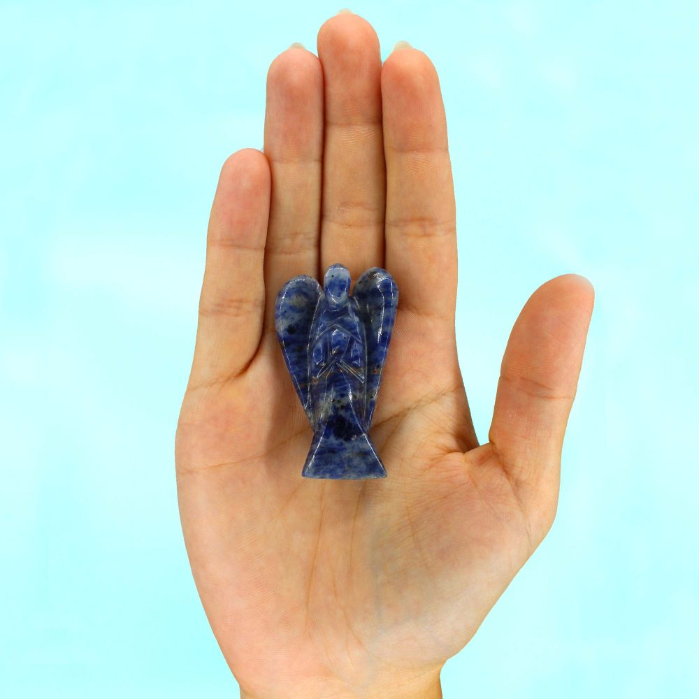 A blue, stone-carved angel rests on an open palm. The hand is centered against a pale blue background.