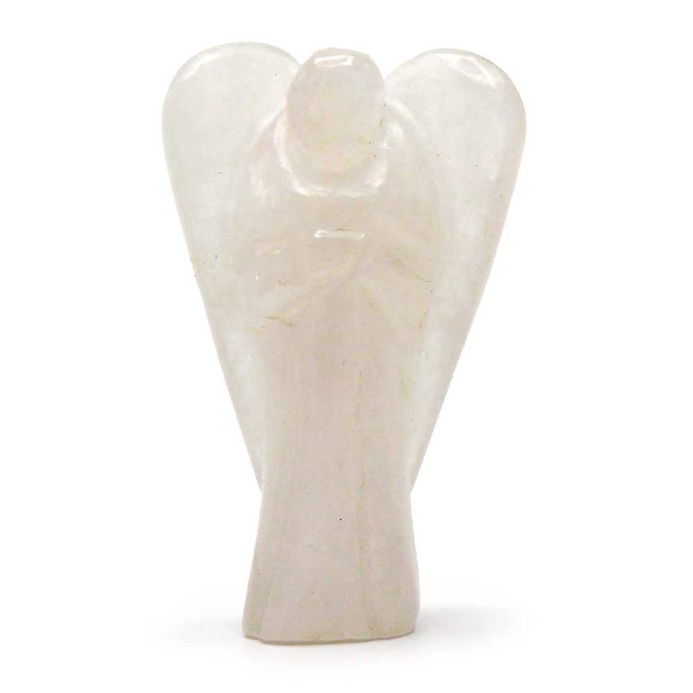 A milky quartz angel figurine stands still, wings outspread. The statuette sits on a white surface.