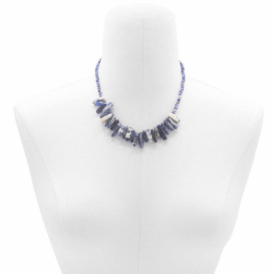 A sodalite chip bead necklace is displayed on a white mannequin. The necklace is comprised of varying shades of blue and white sodalite chip beads.