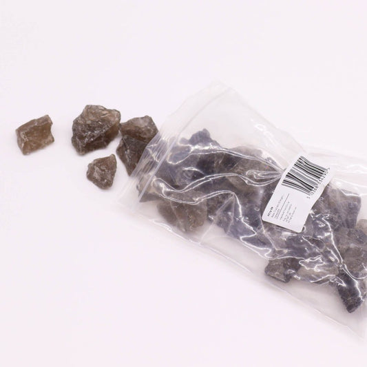 Smoky quartz chunks spill from a plastic bag onto a white surface. The bag's label reads: RCP728, Smoky Quartz (15-20mm), approximately 1 lb., 14.97, Item #2795. 5 813833 279574