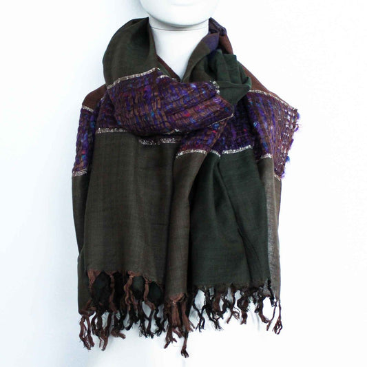A dark-green and brown shawl, woven with a patterned purple section and metallic thread, is draped around a mannequin against a white background.