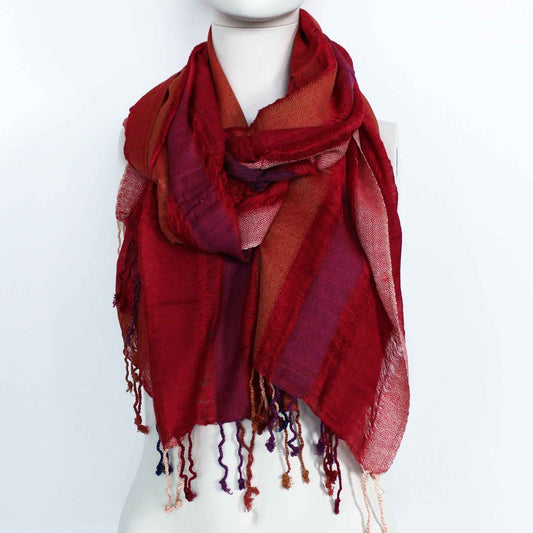 A red striped scarf with tassels is draped around a mannequin's neck, displayed against a white background.