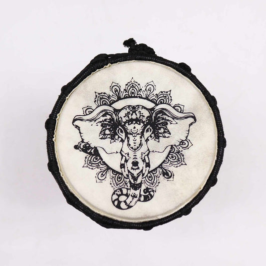A round drum features an intricate black ink design of an elephant on a white background, encircled by ornate patterns. The drum is bordered with a textured black rope.