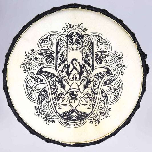 Circular drum features an intricate black Hamsa hand design in the center, surrounded by floral and abstract patterns on a light background. The drum has a dark border.