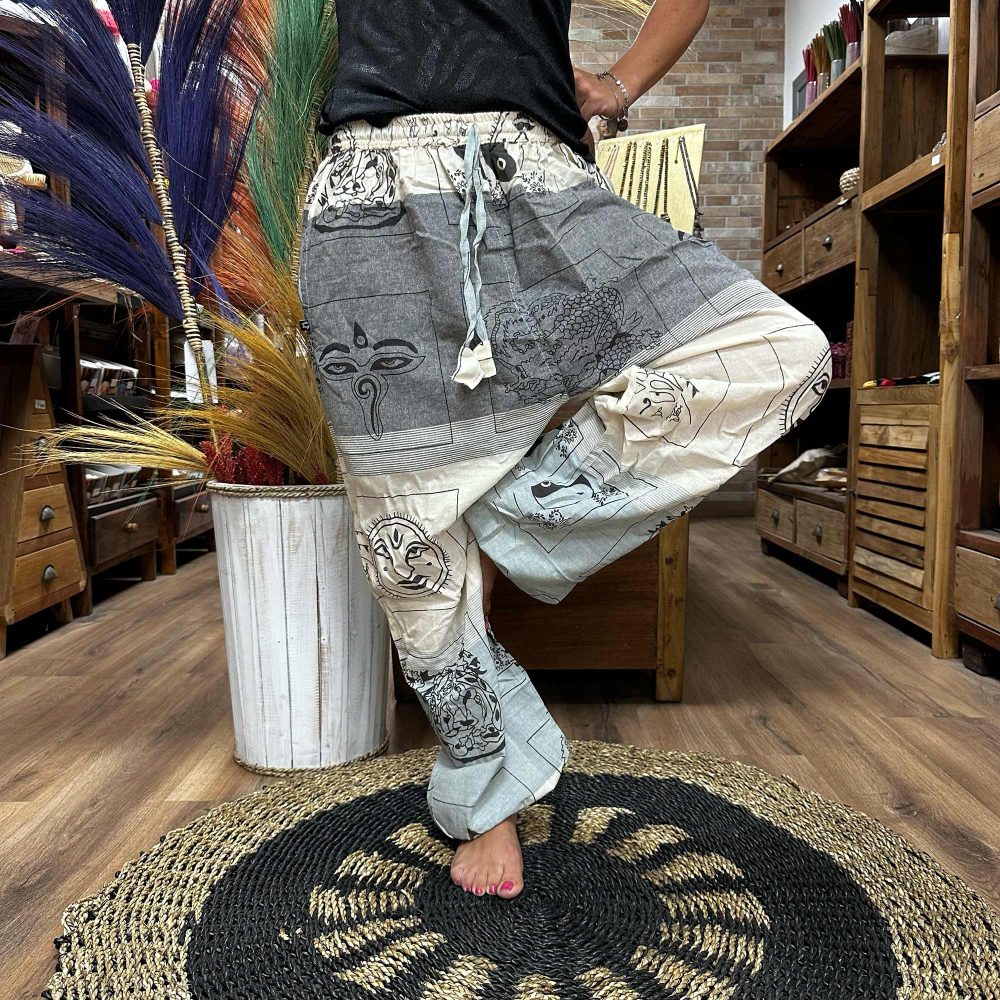 Printed harem pants are being modeled in a shop. The pants feature various Asian-inspired designs. The setting is a wooden-floored store with wooden furniture.