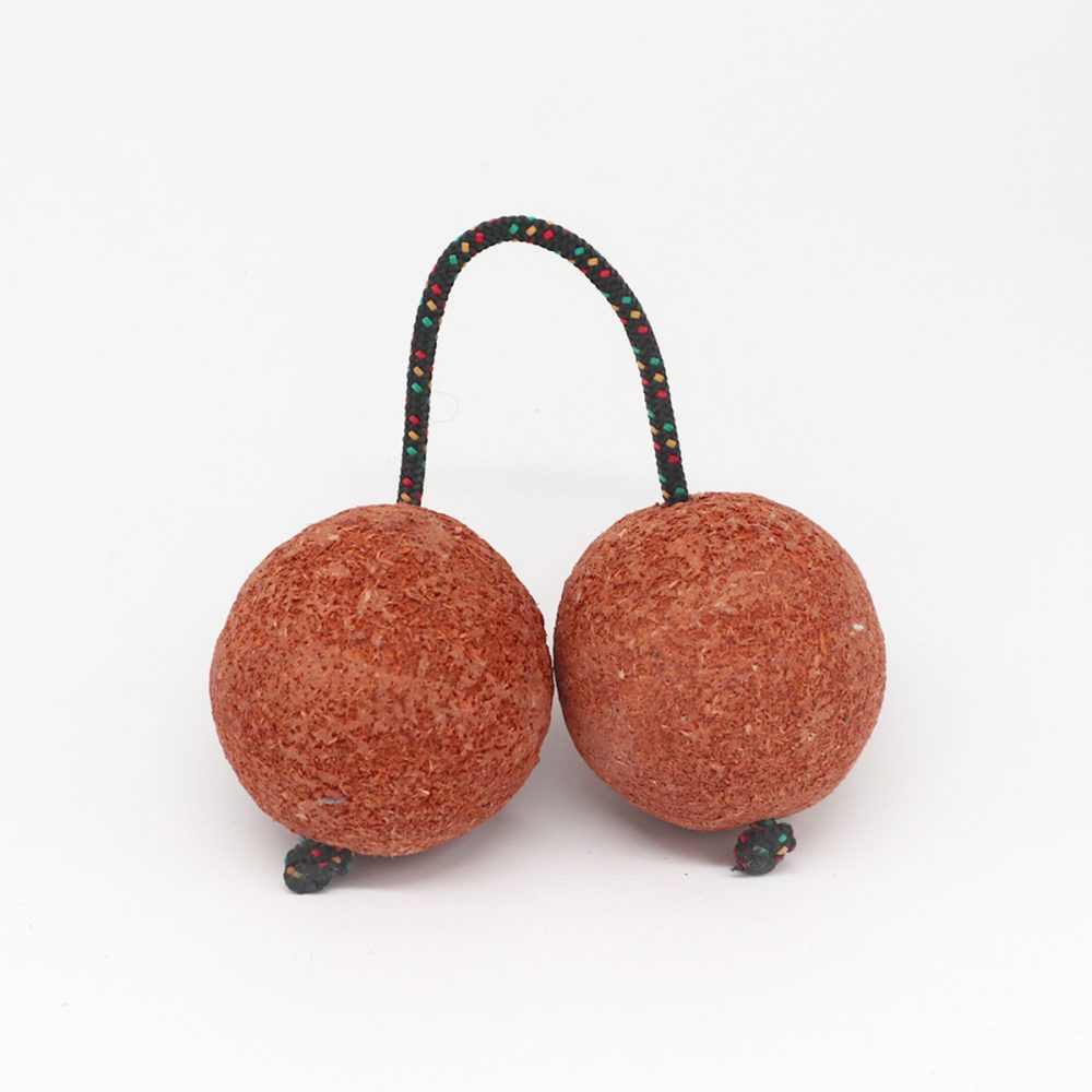 Two textured, brown spherical balls connected by a looped, multicolored rope on a white background, resembling traditional percussion instruments called maracas.