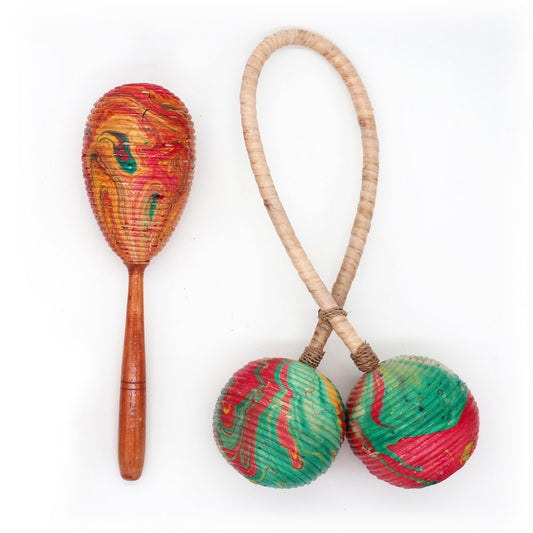 A maraca with a wooden handle and multicolored swirl design sits beside connected spherical maracas with braided handles, set against a plain white background.