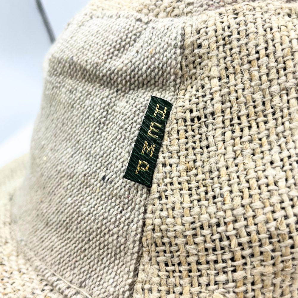 A hemp hat, displaying a "PURE HEMP" label, rests on a plain white background.