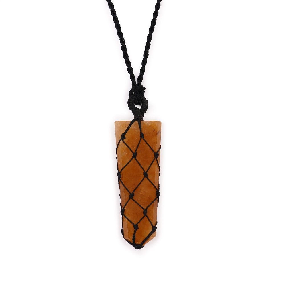 A long orange crystal is suspended by a knotted black cord necklace. The crystal is enclosed in a knotted net, against a white background.