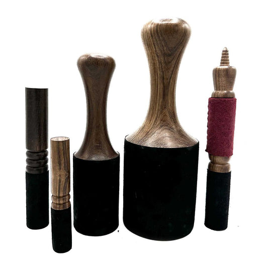 Four wooden mallets, varying in size, with black felt bottoms, are displayed against a white background.