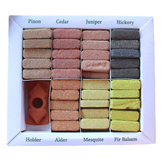 Incense bricks are arranged in a white box, each row labeled: Pinon, Cedar, Juniper, Hickory, Holder, Alder, Mesquite, Fir Balsam. A separate slot contains a ceramic holder.