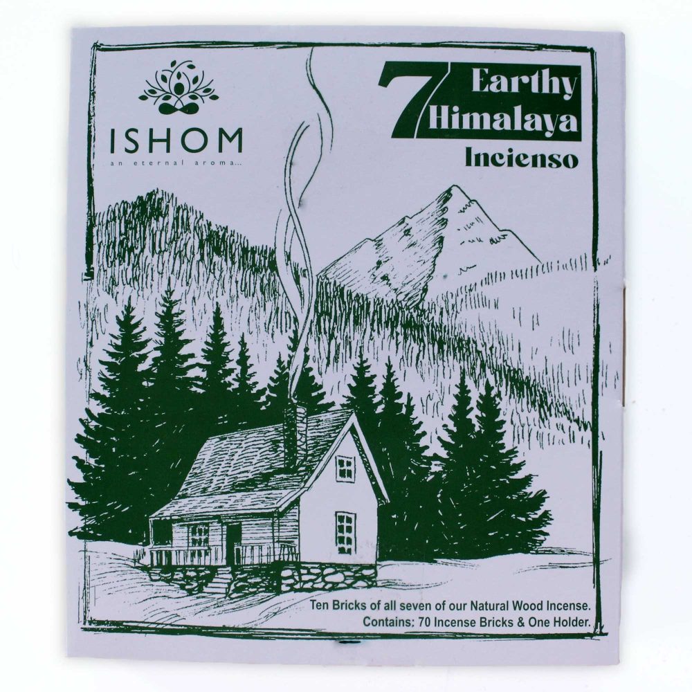 A rustic cabin sits amidst pine trees, emitting smoke from its chimney, with mountain peaks in the background. Text: "ISHOM an eternal aroma... 7 Earthy Himalaya Incienso. Ten Bricks of all seven of our Natural Wood Incense. Contains: 70 Incense Bricks & One Holder."