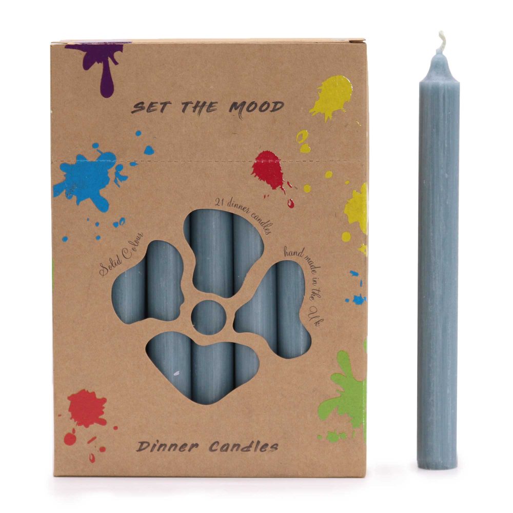 A cardboard box decorated with paint splatters holds blue candles behind a cut-out, next to a single, tall, blue candle. Text reads: "SET THE MOOD, Solid Colour, 21 dinner candles, hand made in the Uk, Dinner Candles".