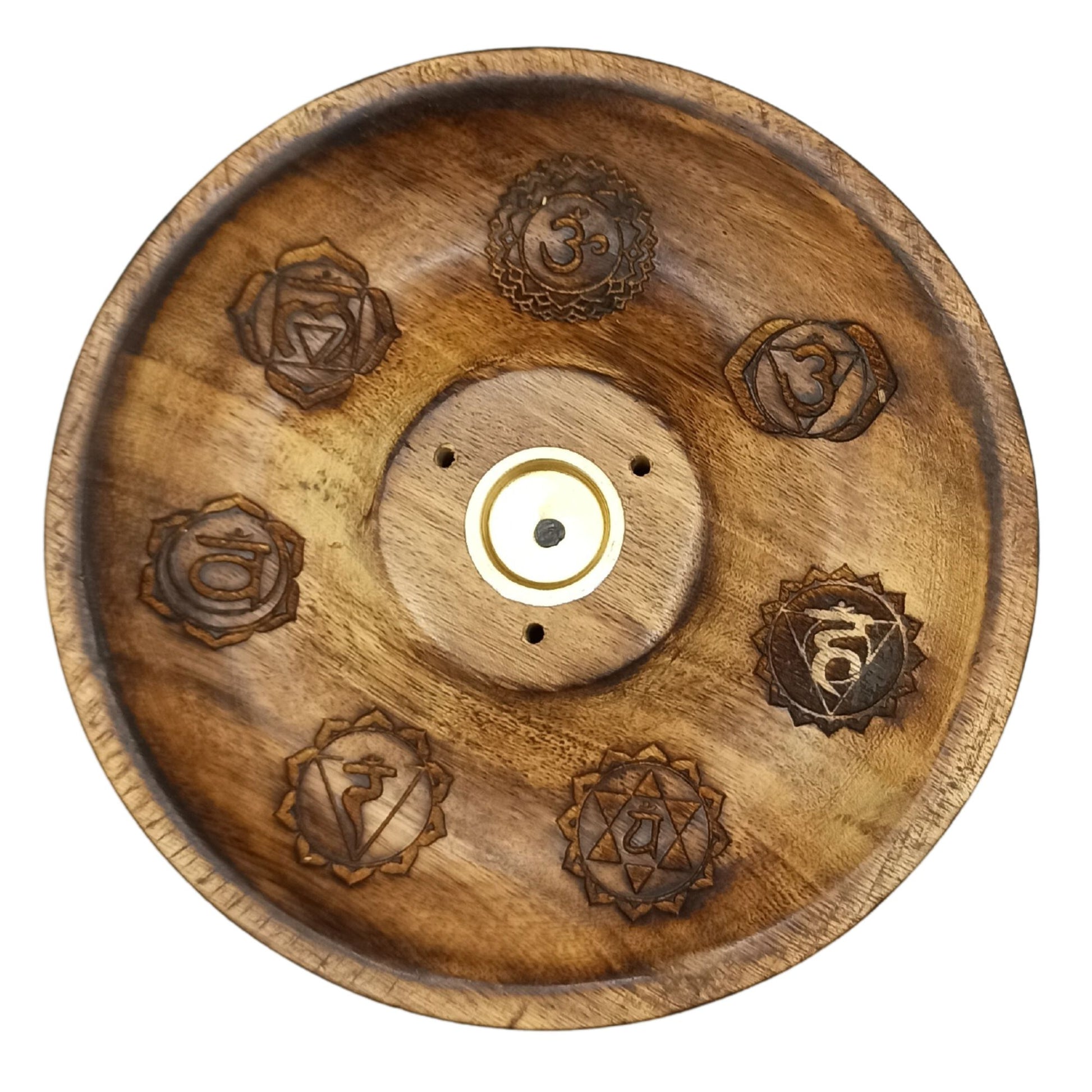 Wooden incense holder with carved chakra symbols, including "Om", arranged in a circular pattern. Set in a smooth, polished wooden context with a central round metal insert and three small holes for incense sticks.