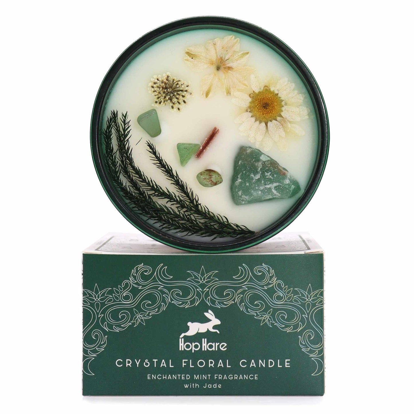 A candle with flowers and jade sits atop a green box that reads "Hop Hare CRYSTAL FLORAL CANDLE ENCHANTED MINT FRAGRANCE with Jade".
