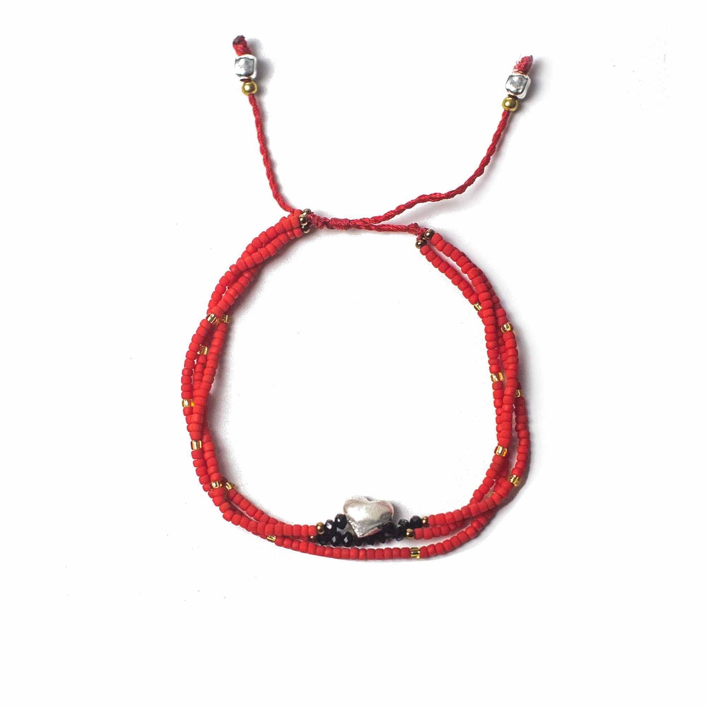 A red, beaded bracelet circles, fastened with a red cord and silver beads on a white background. A small, metallic heart sits centered between black beads.