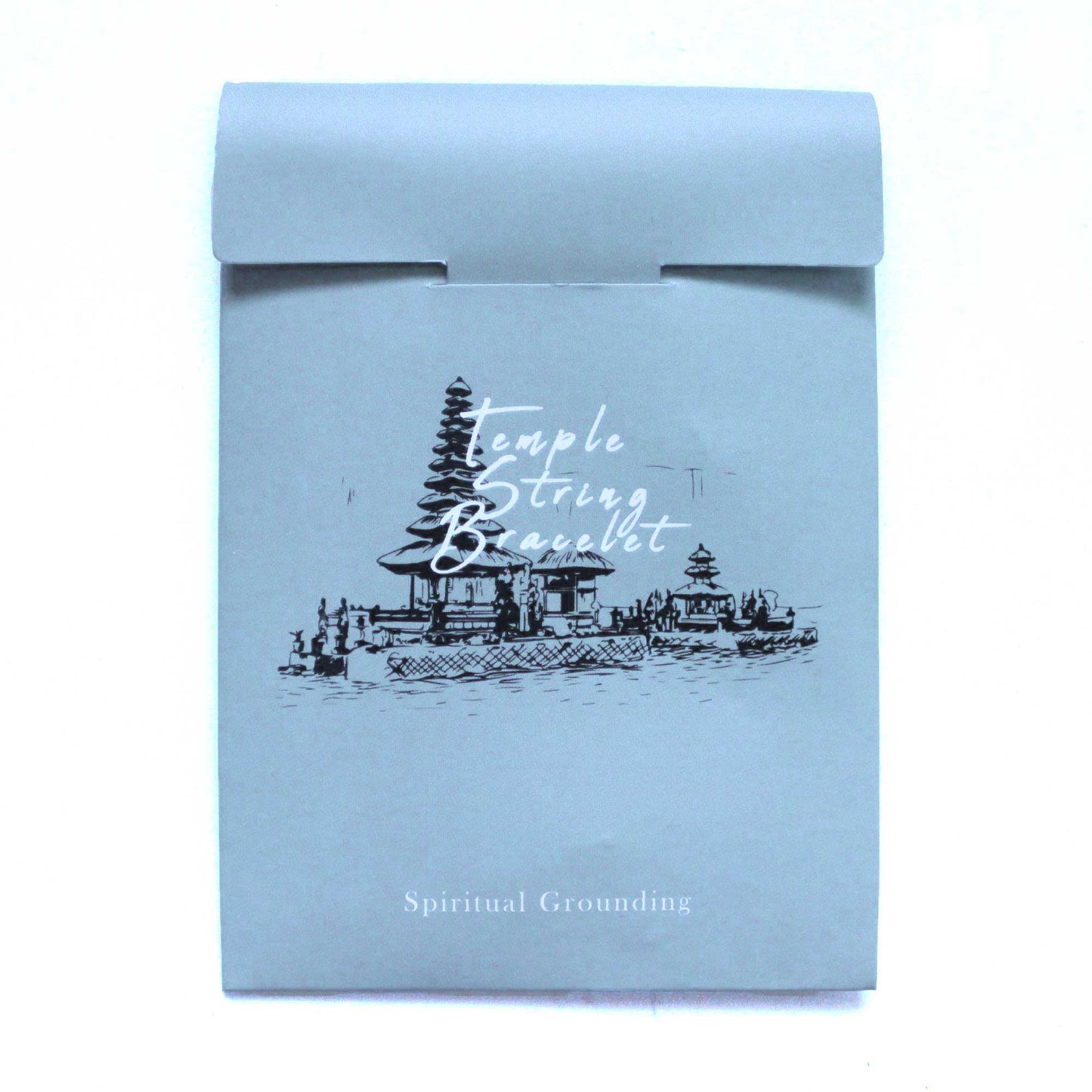 A blue, rectangular paper packaging has an image of a temple complex with the superimposed white text "Temple String Bracelet" and the text "Spiritual Grounding" below.
