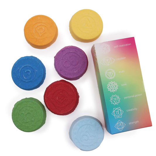 Colorful circular disks with embossed symbols are arranged around a rainbow-gradient box. The box lists: "self-realization, intuition, truth, love, personal power, creativity, strength" alongside various chakra symbols.