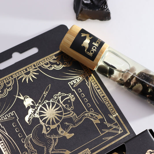 A "hop hare" oil roller with a wood cap sits on a black card with a gold design; a knight on horseback rides beside a castle. Text on the card says "Attracts money and friendship."
