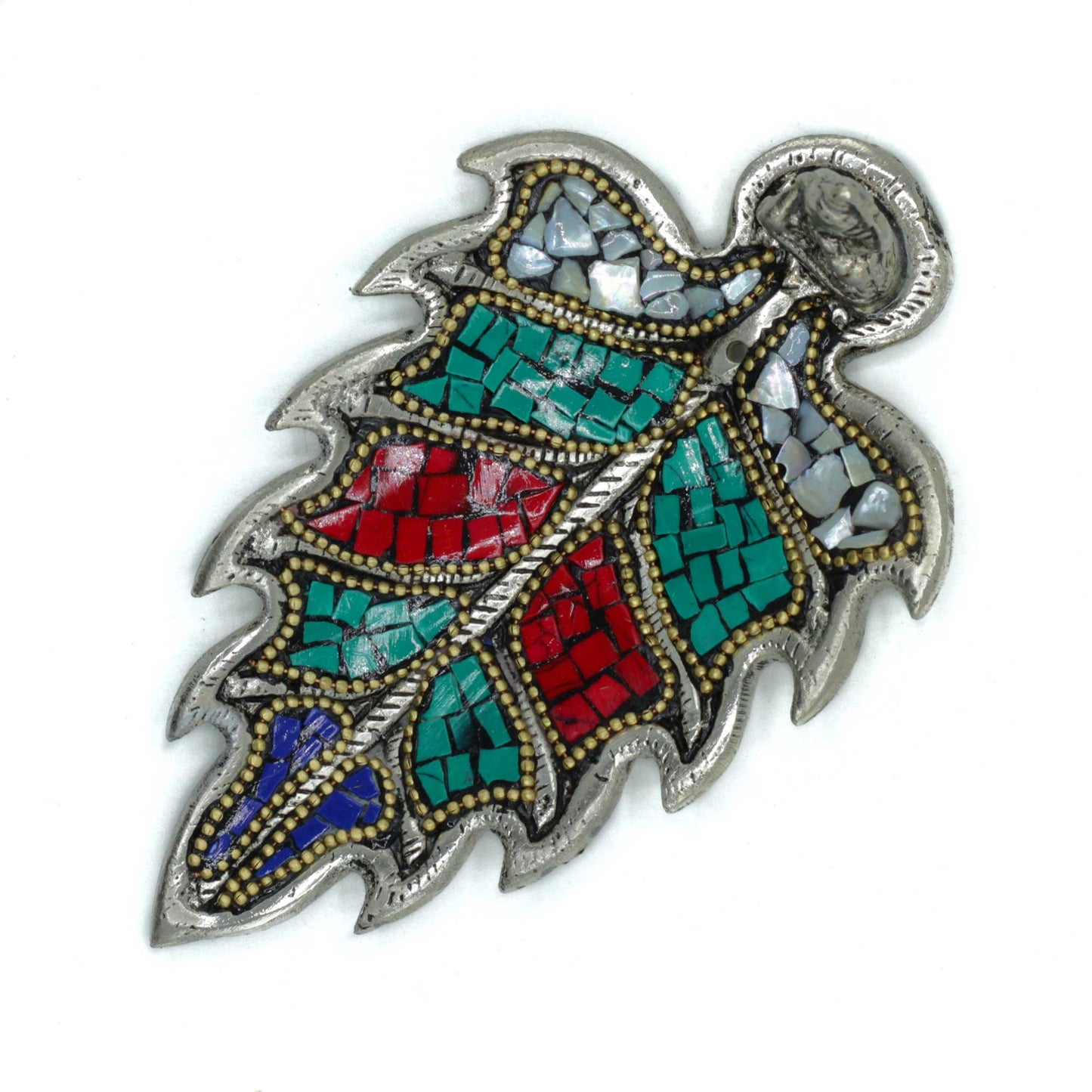 A metal leaf-shaped brooch features colorful mosaic tiles in red, green, blue, and white, bordered by small gold beads, set against a plain, white background.