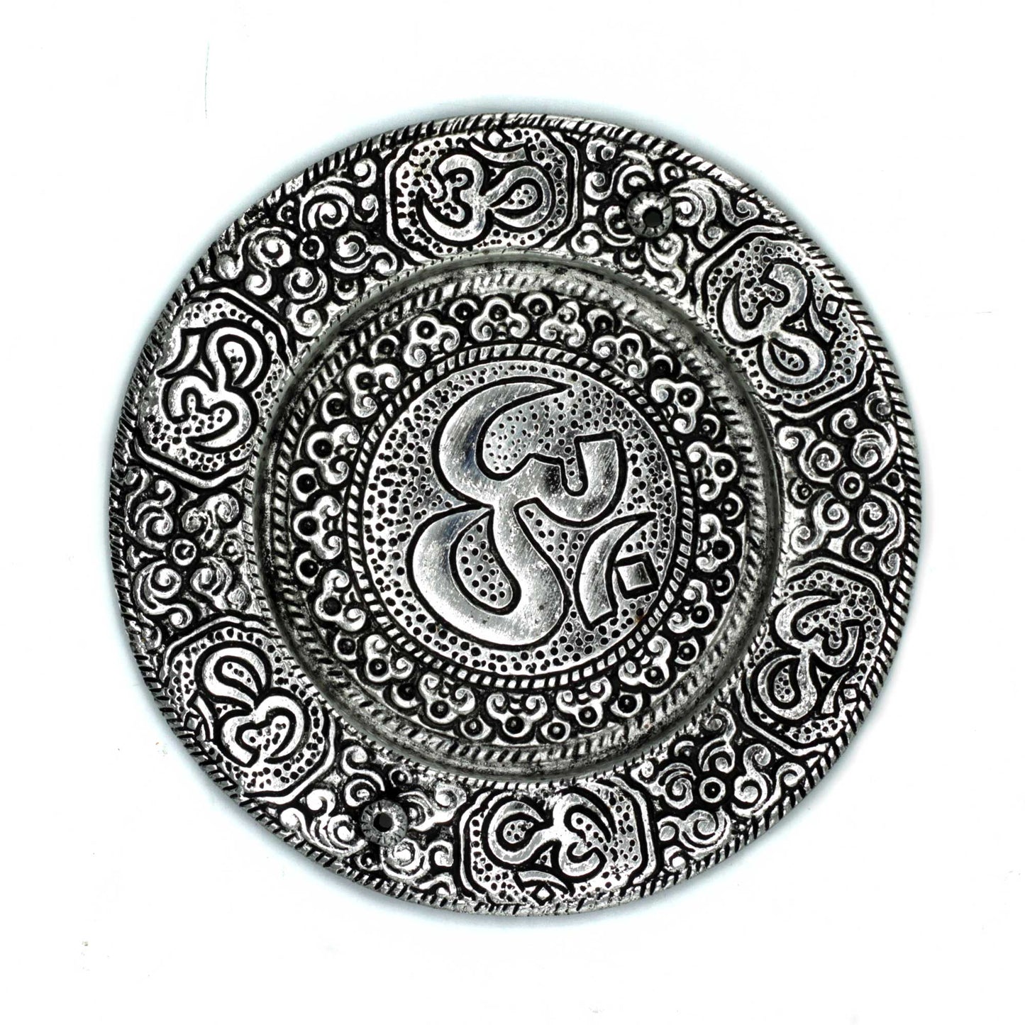 A circular decorative plate displays intricate patterns and the "Om" symbol engraved at the center, surrounded by ornate designs. The plate has a metallic appearance against a plain background.