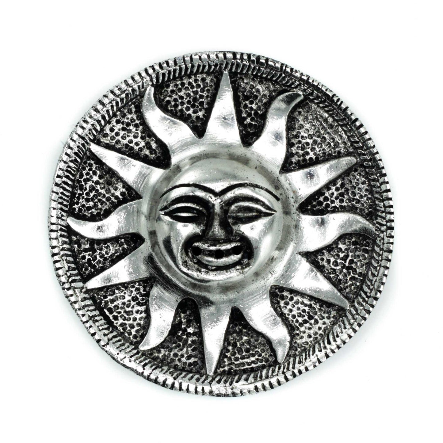 A metallic sun sculpture with a smiling face, featuring prominent rays extending outward, surrounded by a textured circular border, against a plain white background.