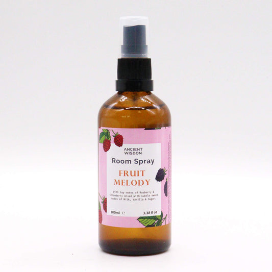 A brown glass bottle containing room spray sits on a white background. The spray bottle is labeled “Fruit Melody” room spray by Ancient Wisdom. It has a black spray top.