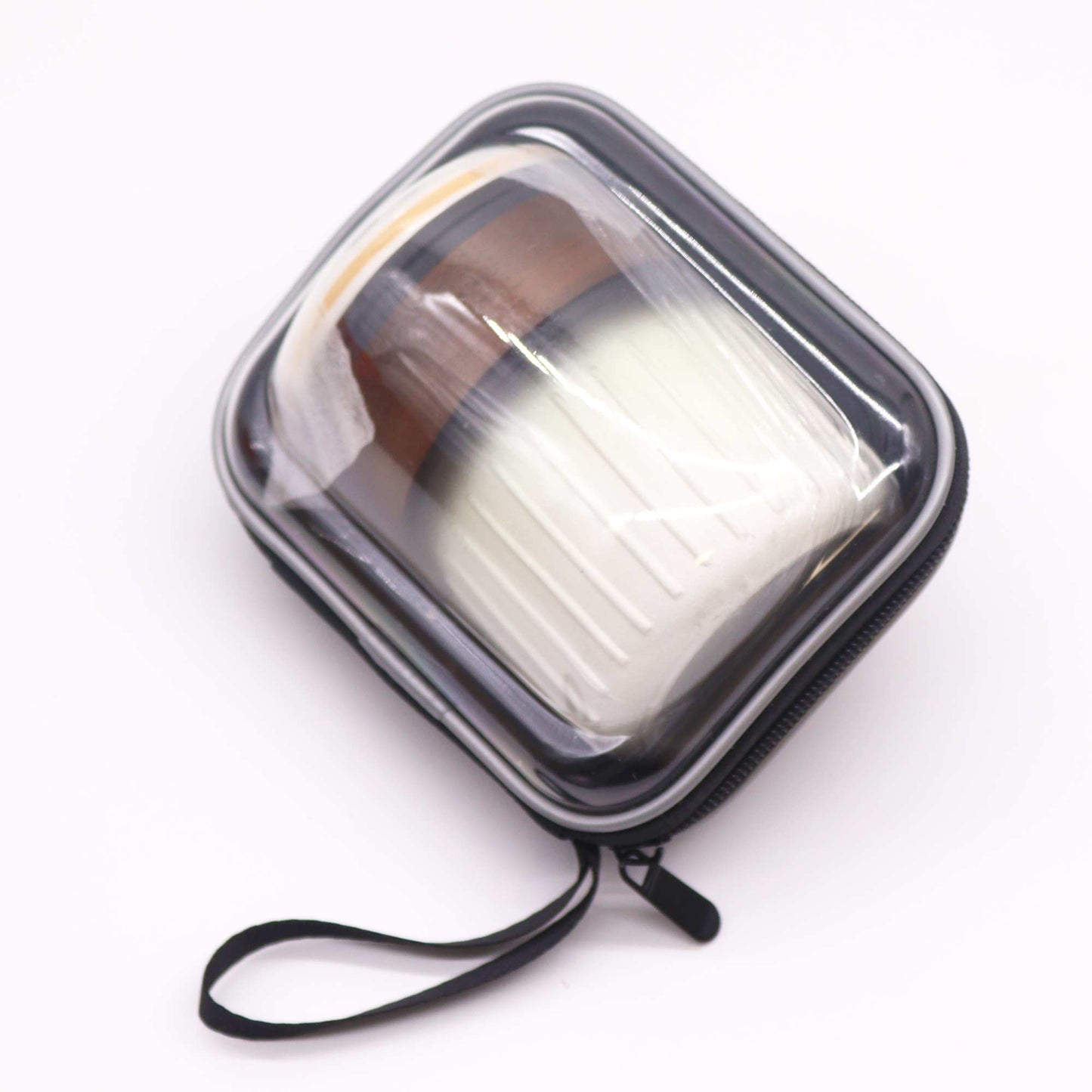 A cylindrical container with brown and white stripes sits inside a zipped, clear plastic carrying case; on a white surface.