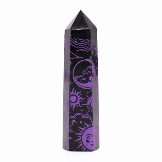 A black crystal tower with a pointed top is adorned with intricate purple celestial designs, including suns and crescent moons, set against a plain white background.