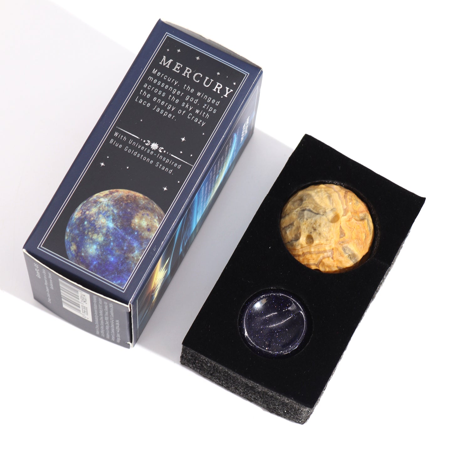 A Crazy Lace Jasper sphere and a Blue Goldstone stand rest in a black display case; the items are packaged in a navy box featuring an image of Mercury and descriptive text.