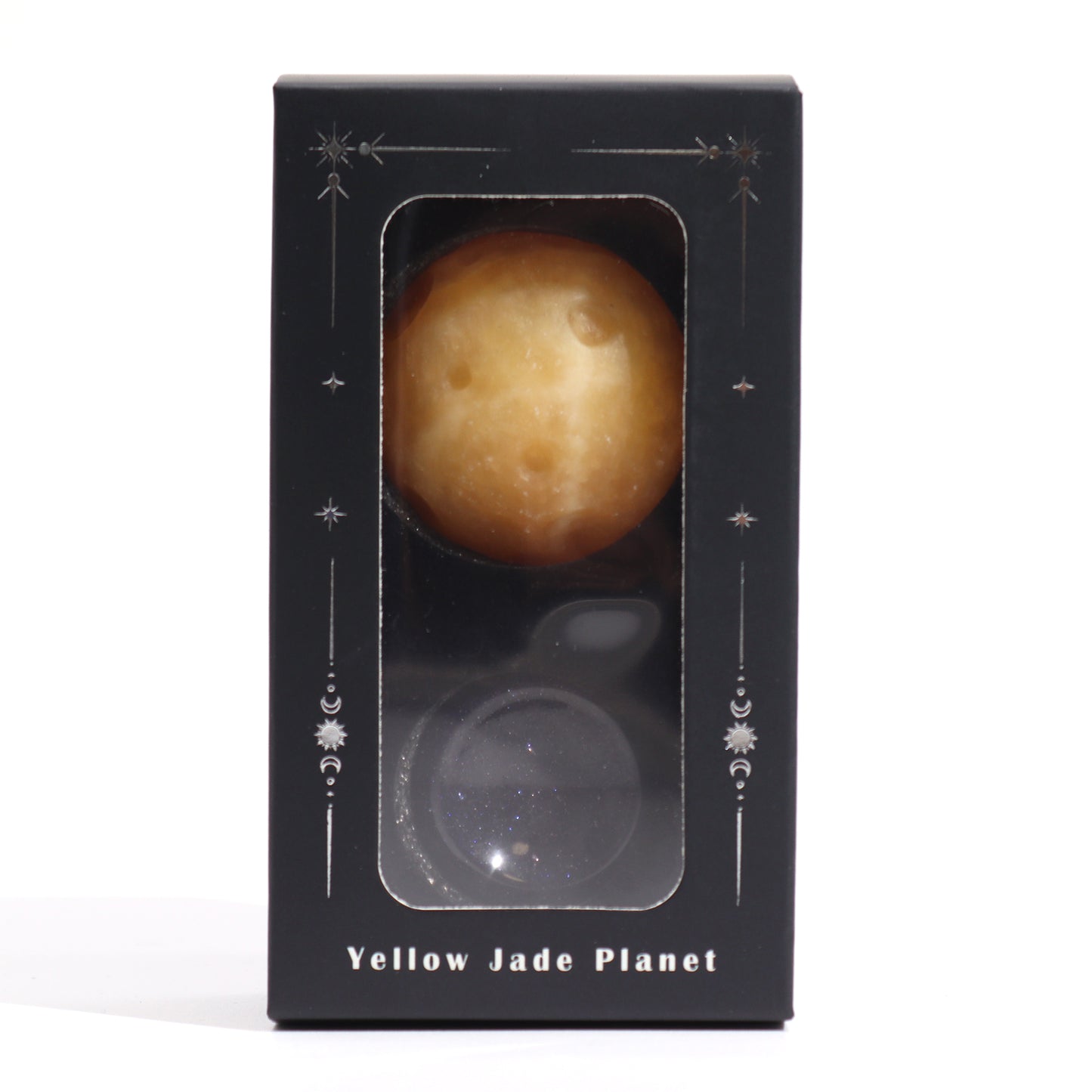 A two-part sphere set, one yellow and one dark blue, sits inside a black box with celestial designs. The box is labeled “Yellow Jade Planet”.