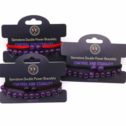 Three amethyst bracelets, each with a coordinating cord, are displayed on individual cards. The cards advertise "Gemstone Double Power Bracelets" and "CONTROL AND STABILITY," identifying the stones as Amethyst.