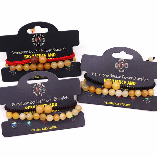 Three gemstone bracelets, displayed on black cards, feature yellow aventurine beads strung on red, black, and brown cords. The cards advertise "Gemstone Double Power Bracelets, Resilience and ..." One card also specifies "Yellow Aventurine".
