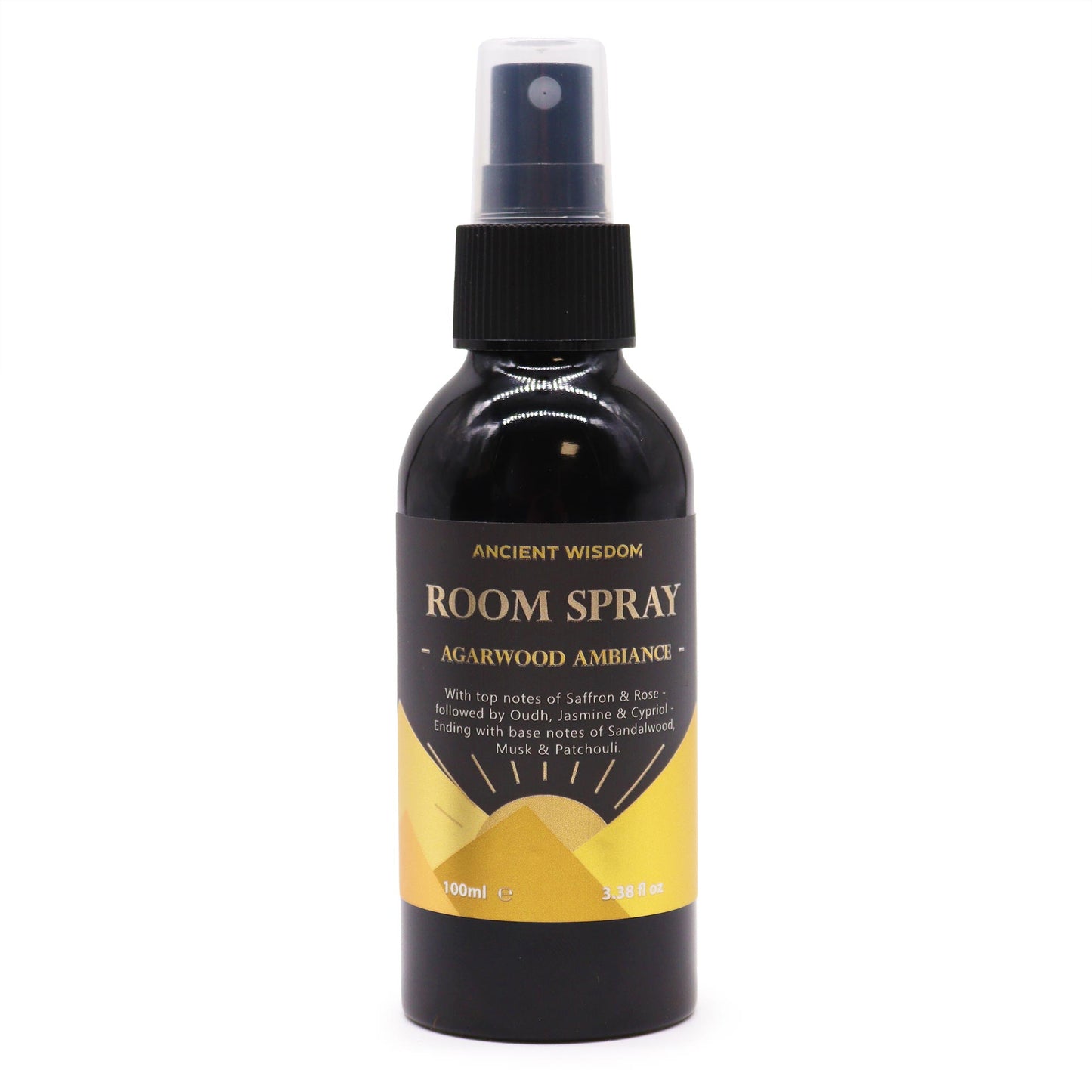 A dark-colored glass bottle, containing room spray, sits against a white background. The spray bottle is labeled “ANCIENT WISDOM ROOM SPRAY - AGARWOOD AMBIANCE -” with scent notes listed. The bottle shows volume in milliliters and fluid ounces.