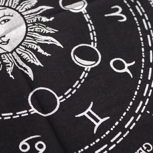 A stylized sun and moon, along with astrological symbols, are printed on black fabric; they are interconnected by thin lines forming a circular pattern.