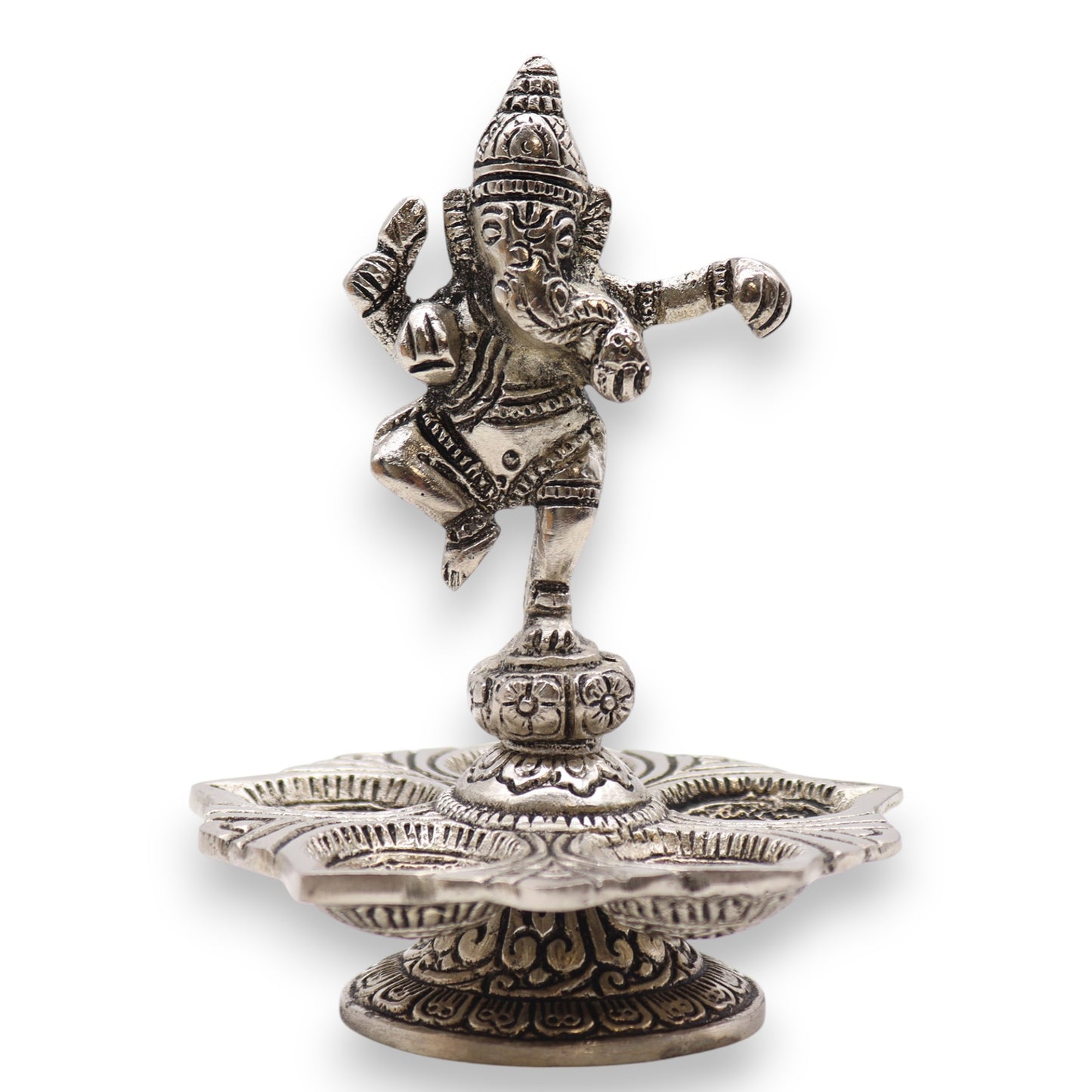 A silver figurine of a dancing deity stands gracefully atop an intricately designed, lotus-shaped base, surrounded by ornate details in a traditional artistic style.